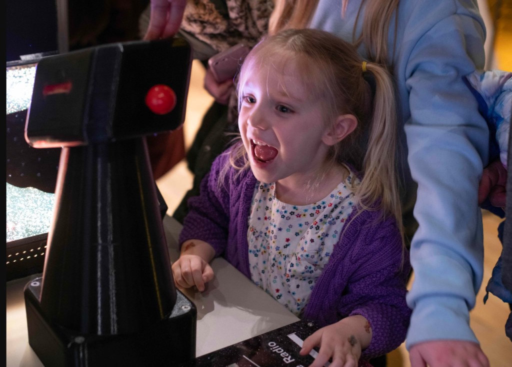 Photo of a young girl interacting with one of the exhibits.